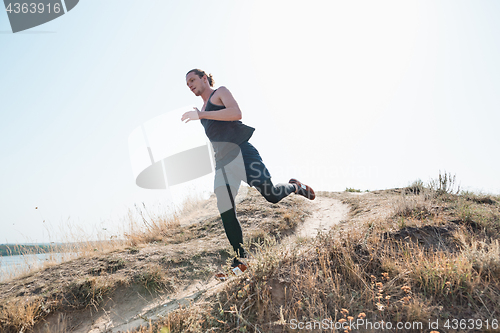 Image of Running sport. Man runner sprinting outdoor in scenic nature. Fit muscular male athlete training trail running for marathon run.