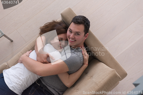 Image of young handsome couple hugging on the sofa