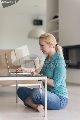 Image of young women using laptop computer on the floor