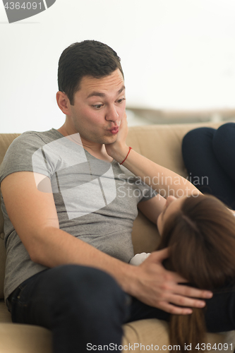 Image of young handsome couple hugging on the sofa