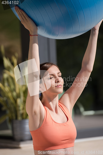 Image of woman doing exercise with pilates ball
