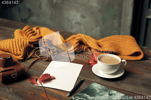 Image of Opened craft paper envelope , autumn leaves and coffee on wooden table