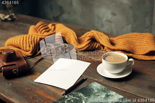 Image of Opened craft paper envelope , autumn leaves and coffee on wooden table