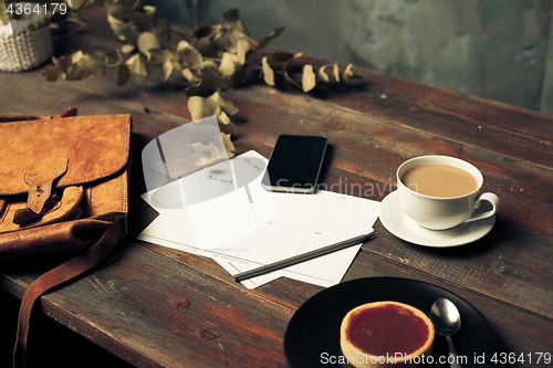 Image of Opened craft paper envelope , autumn leaves and coffee on wooden table