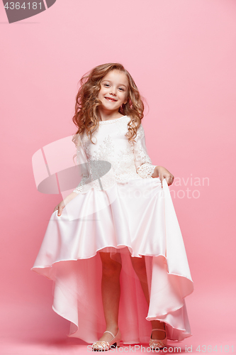 Image of Full length of beautiful little girl in dress standing and posing over white background