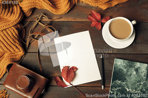 Image of Opened craft paper envelope , autumn leaves and coffee on wooden table