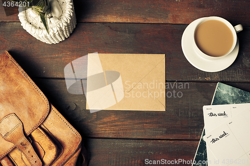 Image of Opened craft paper envelope , autumn leaves and coffee on wooden table