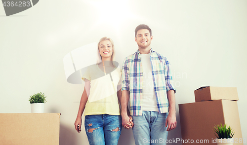 Image of smiling couple with big boxes moving to new home