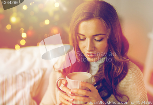 Image of happy woman drinking cocoa at home for christmas