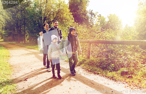 Image of happy family with backpacks hiking in woods