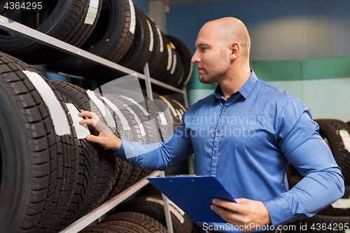 Image of auto business owner and wheel tires at car service
