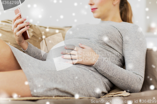 Image of happy pregnant woman with smartphone at home