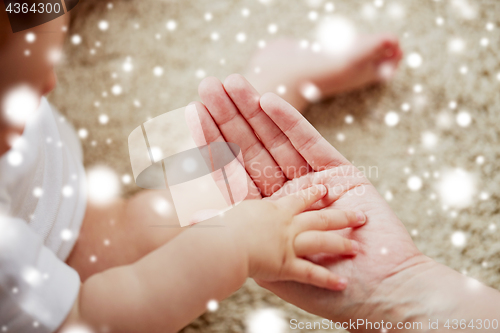 Image of close up of little baby and mother hands