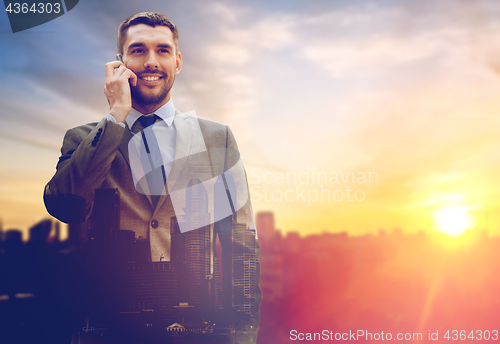 Image of smiling businessman with smartphone outdoors