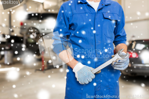 Image of auto mechanic or smith with wrench at car workshop