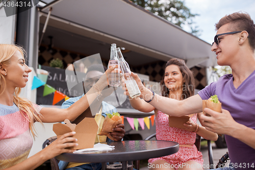 Image of friends clinking drinks and eating at food truck