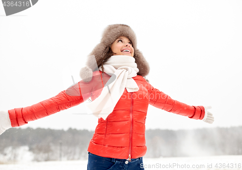 Image of happy woman in winter fur hat outdoors