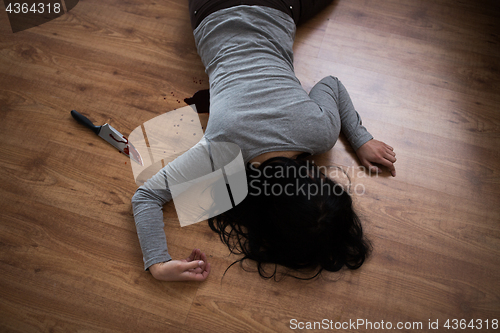 Image of dead woman body lying on floor at crime scene