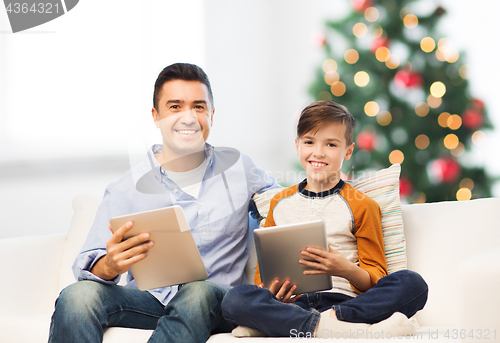 Image of happy father and son with tablet pc at christmas