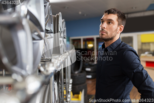 Image of male customer choosing wheel rims at car service