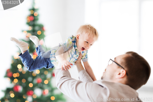 Image of happy father playing with son at christmas