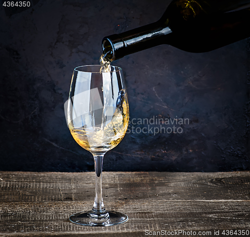 Image of Pouring white wine from bottle