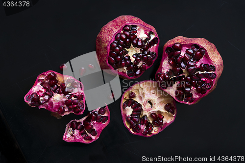 Image of Two pomegranates on a black background