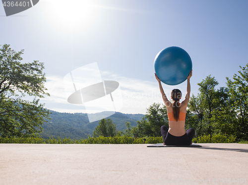 Image of woman doing exercise with pilates ball