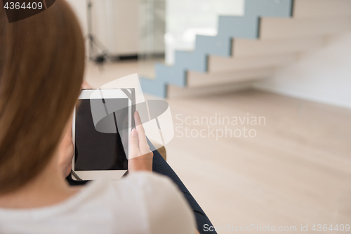 Image of woman sitting on sofa with tablet computer