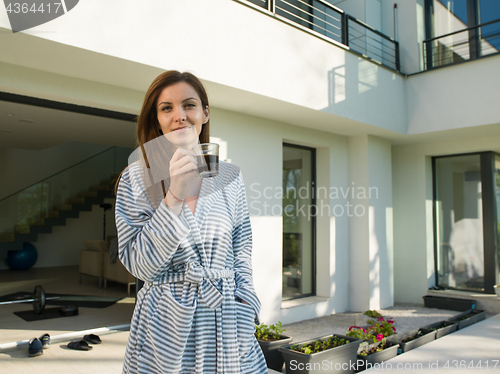 Image of woman in a bathrobe enjoying morning coffee