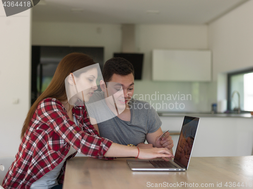 Image of happy young couple buying online