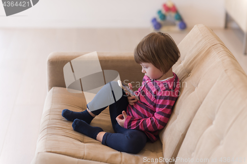 Image of little girl playing games on smartphone