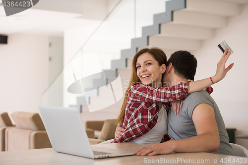 Image of happy young couple buying online