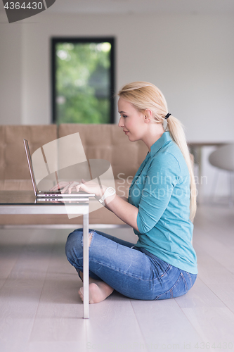 Image of young women using laptop computer on the floor