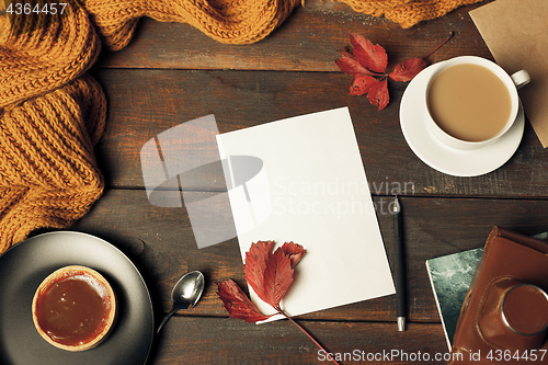 Image of Opened craft paper envelope , autumn leaves and coffee on wooden table