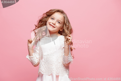 Image of The beautiful little girl in dress standing and posing over white background