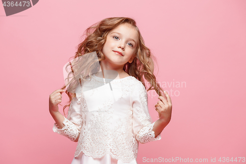 Image of The beautiful little girl in dress standing and posing over white background