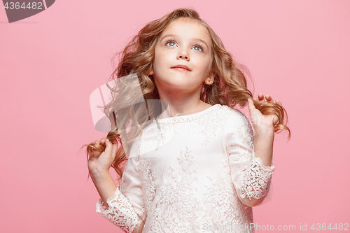Image of The beautiful little girl in dress standing and posing over white background