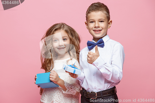 Image of Boy and girl standing in studio on pink background