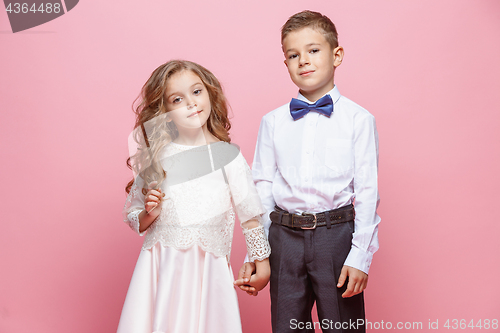 Image of Boy and girl standing in studio on pink background