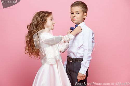 Image of Boy and girl standing in studio on pink background