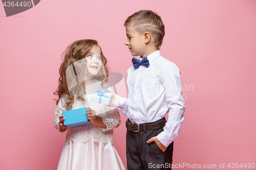 Image of Boy and girl standing in studio on pink background