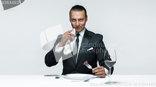 Image of Bloody Halloween theme: crazy man with a knife, fork and meat