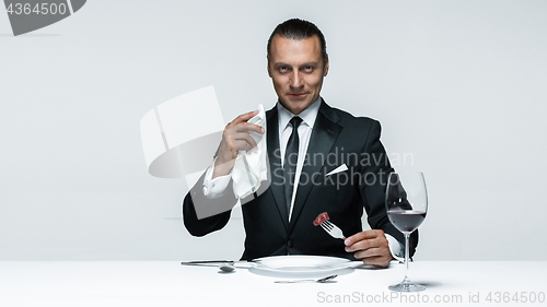 Image of Bloody Halloween theme: crazy man with a knife, fork and meat