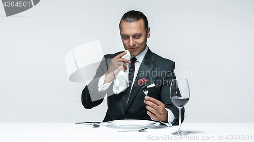 Image of Bloody Halloween theme: crazy man with a knife, fork and meat