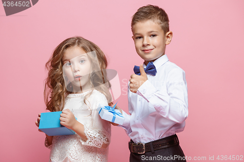 Image of Boy and girl standing in studio on pink background