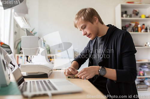 Image of fashion designer with sewing machine at studio