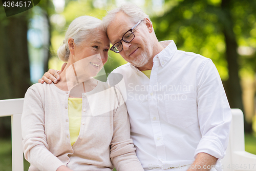 Image of happy senior couple sitting on bench at park