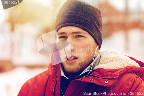 Image of man with earphones listening to music in winter