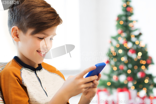 Image of boy with smartphone at home at christmas